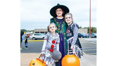 The Kopff sisters, Violet, 9; Raynn, 8; and Lyric, 5, all from Arnold, visit the Arnold Chamber of Commerce’s trunk or treat and food drive.