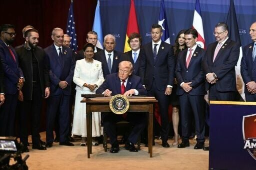 US President Donald Trump, surrounded by several Latin American leaders, signs a proclamation at the 'Shield of the Americas' summit in Doral, Florida