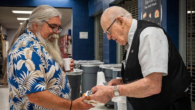 Don Wieland, right, hands out cards at a Leader senior expo.