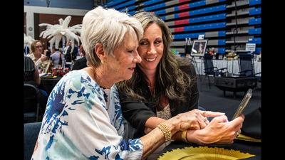Susan Abrams, left, and Tasha Welsh, both of Festus, on March 28 use a phone to bid on auction items during the Jefferson College Foundation’s annual “Lights…Camera…Auction!” event in the Jefferson College Field House on the Hillsboro campus.