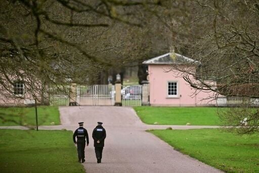 Police officers walk towards the entrance to Royal Lodge, a 30-room property in Windsor and past residence to Britain's former prince Andrew where police said they are still conducting a search