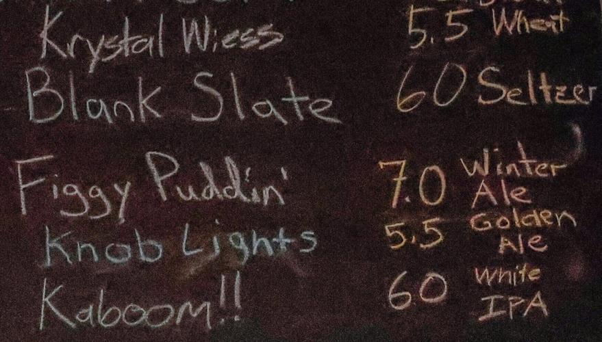 A handwritten sign hangs on a wall of the Lost Art Taproom