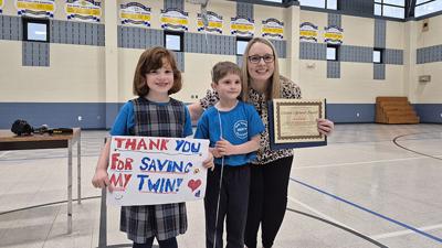 Sammi, left, and Rick Krausz thank Holy Family Catholic School Principal Bridget Brennell for her actions on March 11. Brennell received a LifeSaver Award from the Rock Community Fire Protection District on April 11 for helping Rick when he was choking.