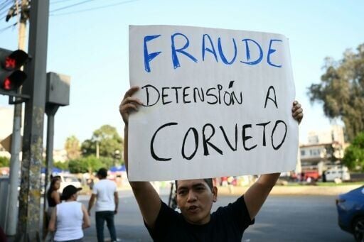 A man holds a banner reading "Fraud, arrest Corvetto" (referring to Peru’s National Office of Electoral Processes chief, Piero Corvetto) outside the National Office of Electoral Processes (ONPE) in Lima