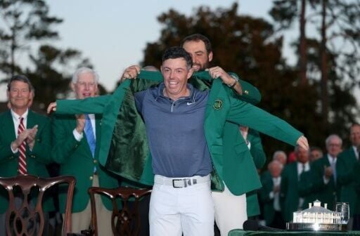 Masters winner Rory McIlroy is awarded the Green Jacket by outgoing champion Scottie Scheffler after the final round of the 2025 tournament at Augusta National