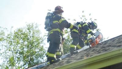 Festus firefighters use a power saw to cut through the roof while training.