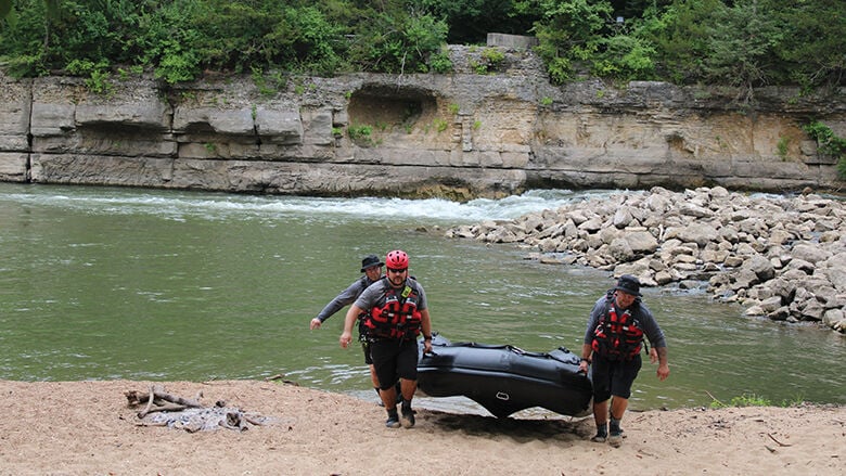 High Ridge Fire Protection District firefighters carry an inflatable rescue boat back to a trailer for transport at Rockford Park.