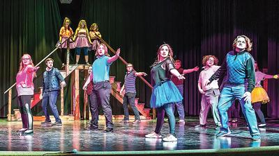 Cast members dance across the stage in the opening scene of the Windsor High production of “Footloose: The Musical.”