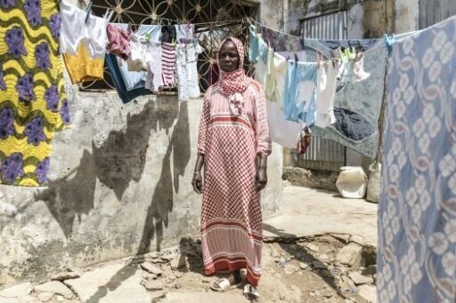 Fatou Ngom ekes by with her three children living in a single room with a shared courtyard