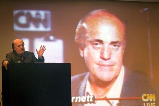 Arnett giving a speech in front of an image of him during his CNN days at a lecture hall in Shantou, in China's southern province of Guangdong