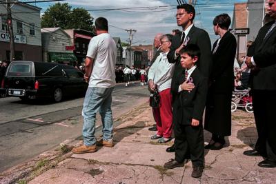 Mourners on Staten Island watch a funeral procession for a firefighter killed during the 9/11 terrorist attacks.
