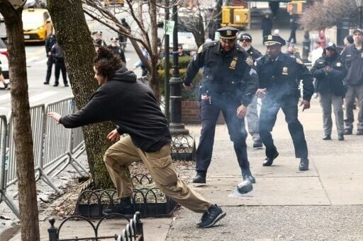 A man flees after throwing a device during a protest organized by far-right influencer Jake Lang outside the official residence of the New York mayor