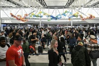 Travelers wait in line at a security checkpoint at George Bush Intercontinental Airport in Houston, Texas on November 7, 2025