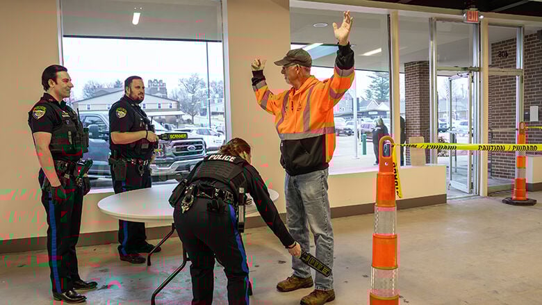 Festus police officers conduct security screenings as people arrive to the meeting.