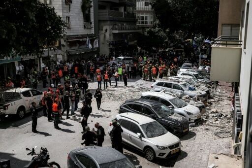 First responders next to a building hit by an Iranian strike in Ramat Gan, central Israel