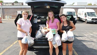 Carly Shipp, Kayla Wahl and Josephine O’Brien unload donations the Gateway Food Pantry received during its first Doorstep Food Drive.