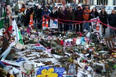 People pay homage to Alex Pretti at the makeshift memorial set up near the street where he was shot and killed by federal immigration agents in Minneapolis, Minnesota, on January 31, 2026