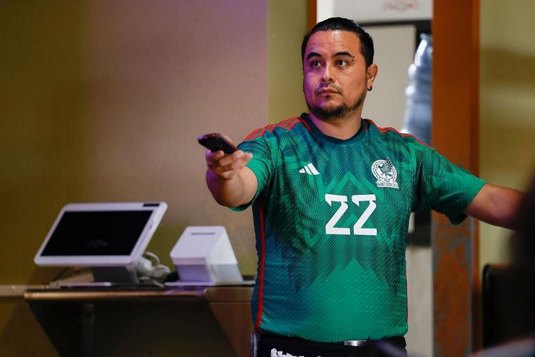 Waiter Santiago Porras switches the channel to a different broadcast