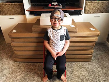 Blake Bahr with boxes of the cookies his family bought to thank employees at Cardinal Glennon Hospital.
