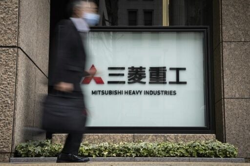 A man walks past Mitsubishi Heavy Industries outside the company's headquarters in Tokyo on February 24, 2026