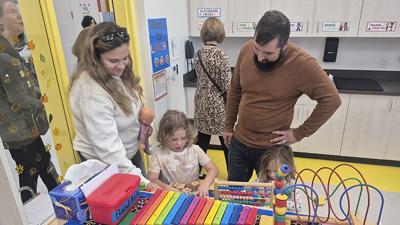 Courtney and Adam Ernst watch their children, Cameron, 5, and Baylee, 4, play in an Early Childhood Center classroom.