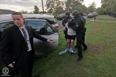 This handout picture released by the New South Wales Police Force on February 25, 2026, shows officers detaining a man following his arrest over the alleged kidnapping and murder of an elderly grandfather in a suspected case of mistaken identity