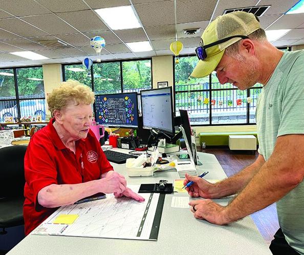 Marilyn Parr issues the final library card of her 44-year career to Crystal City Mayor Mike Osher.