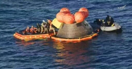 This video grab made from a NASA livestream shows Artemis II crewmembers (in orange suits) being extracted from their spacecraft after splashing down in the Pacific Ocean off the coast of San Diego, California