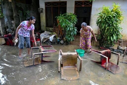 Residents salvage their belongings at an inundated house following flash floods in the aftermath of Cyclone Ditwah, in Wellampitiya on the outskirts of Colombo on December 3, 2025
