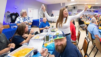 Melissa Lee celebrates Michele Lawrence, left, winning the 50/50 drawing March 21 during the Arnold Police Officers Association's Back the Blue Trivia Night at the Arnold Eagles Club.