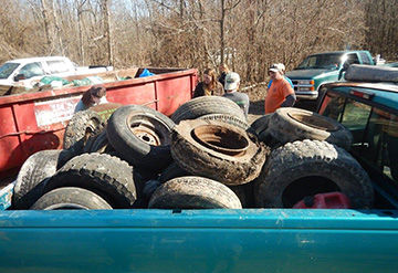 Members of League of Watershed Guardians members with some of the tires they removed at a recent cleanup at Holzer Park in south St. Louis County.