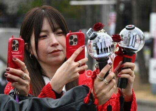 Fans take pictures of BTS light sticks as they arrive at a stadium where the group will perform in Goyang on April 9, 2026.