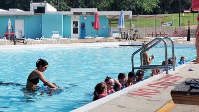 Children line up in the Crystal City Pool for a group swim class.