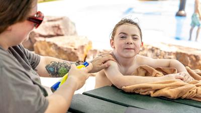 Lindsey Aiello of Herculaneum rubs in the sunscreen she sprayed on her son, Grayson Wideman, 7.