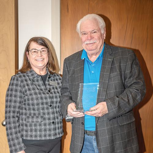 Margie Passmore presents Ron Scaggs with his retirement plaque for his years on the board from 2001 to 2025.