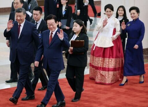 South Korea's President Lee Jae Myung (2nd L) and his wife Kim Hea Kyung (2nd R) wave with China's President Xi Jinping (L) and his wife Peng Liyuan (R) during a welcoming ceremony at the Great Hall of the People in Beijing on January 5, 2026