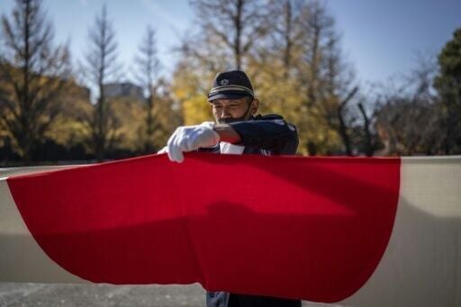 A member of the ultra-nationalist group Taikosha folds a Japanese national flag following a ceremony at Yasukuni shrine on the 84th anniversary of Japan's Pearl Harbour attack