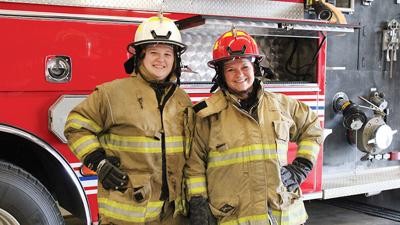 Leader reporters Abby Stetina, left, and Goldie Lowe try on protective gear before joining De Soto Rural Fire Protection District on a training day.