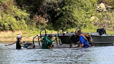 Operation Clean Stream volunteers work to remove a picnic table from the Big River on Aug. 22. Byrnes Mill Mayor Rob Kiczenski, who led a group of around 20 volunteers, said there were two picnic tables found in the river between Rockford Park and Byrne...