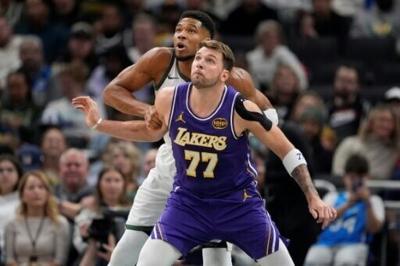 Luka Doncic of the Los Angeles Lakers defends Giannis Antetokounmpo in the Lakers' NBA victory over the Milwaukee Bucks