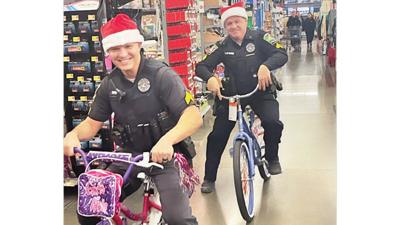 Byrnes Mill Police officers ride children’s bicycles through Walmart in High Ridge during the Byrnes Mill Shop with a Hero event.