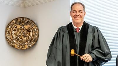 Judge Joseph Rathert wears the late Judge Emerson’s robe and holds his gavel.