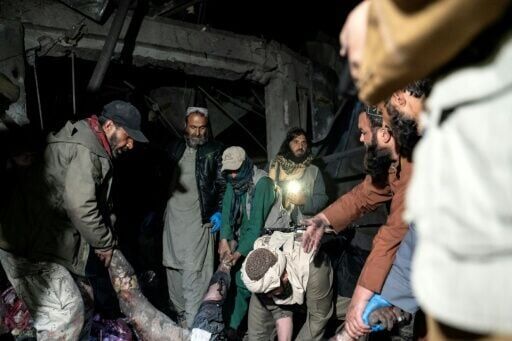 Afghan rescue teams and Taliban security personnel carrying a victim's body following Pakistani airstrikes on a drug rehabilitation centre in Kabul