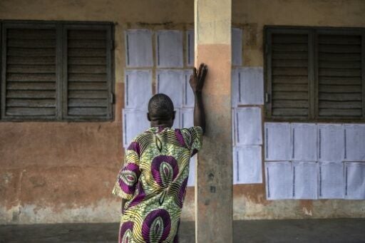A voter looks for his name on the electoral roll at a primary school serving as a polling station in Cotonou, Benin