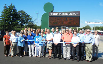 Festus dignitaries gather for ribbon cutting marking installation of electronic sign at Festus Public Library.