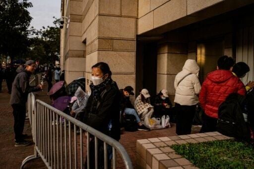 People wait in line outside the West Kowloon Law Courts building to hear the verdict in the national security trial of pro-democracy media tycoon Jimmy Lai in Hong Kong
