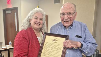 State Rep. Renee Reuter, left, hands Frank Kutilek a resolution from the Missouri House of Representatives on May 27, when the Rock Township Ambulance District named its House 4 after him.