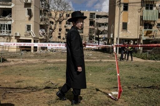 An Israeli Orthodox Jew inspects the site of an Iranian missile strike in Arad on March 22