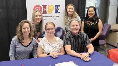 People celebrate Leah’s acceptance into the Succeed program at the University of Missouri-St. Louis during a ceremony in the Seckman High School library.