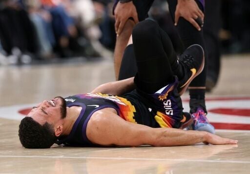 Devin Booker of the Phoenix Suns reacts after twisting is ankle in an NBA loss to the Atlanta Hawks